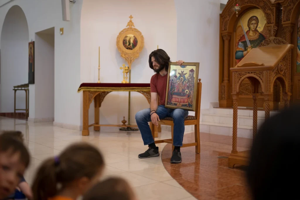 Man presenting religious icon in church setting