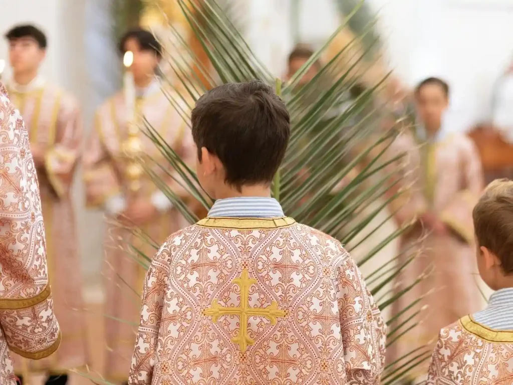 Boys in ornate robes during religious ceremony