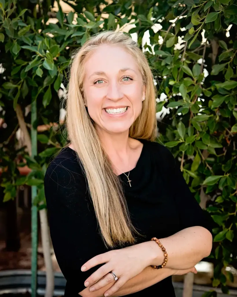 Smiling woman in front of leafy background