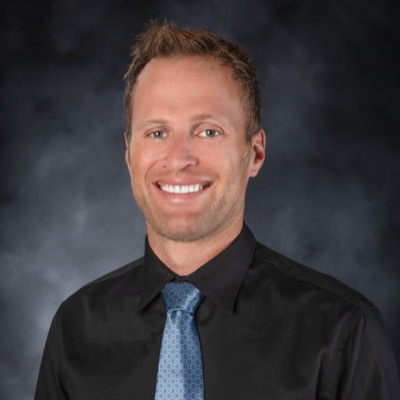 Smiling person in formal attire with tie